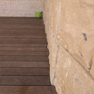 רצפת עץ ליד קיר אבן עם משפך ירוק