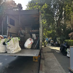 משאית הובלה עם אדם וציוד על המדרכה