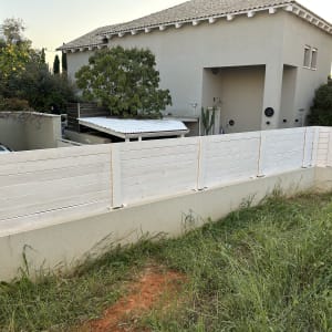 גדר עץ לבנה בחצר בית פרטי