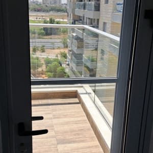 מרפסת עם דלת זכוכית ונוף לבניינים