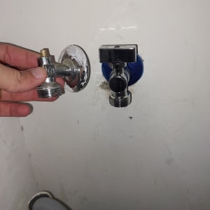 יד מחזיקה ברז מים מתכת ליד צינור גמיש