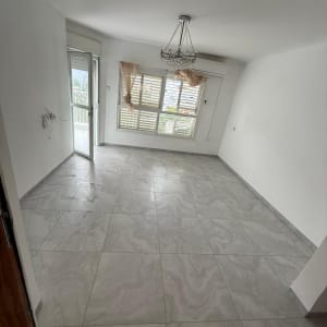 חדר ריק עם רצפת אריחים ונברשת