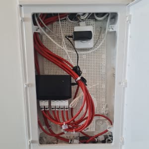 ארון תקשורת עם כבלים אדומים ומתג רשת