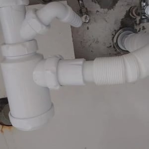 צנרת לבנה עם חיבורים מתחת לכיור
