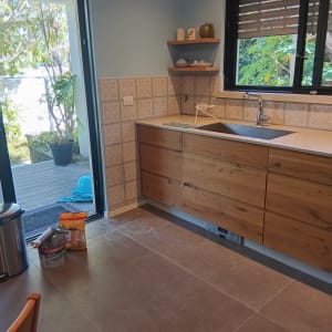 מטבח עם ארונות עץ, כיור וחלון