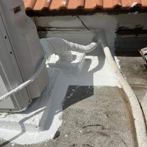 איטום גג עם חומר לבן סביב צינורות ומזגן