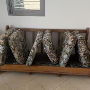 כריות ספת בד מוצבות לייבוש לאחר ניקוי על גבי שלד ספה מעץ