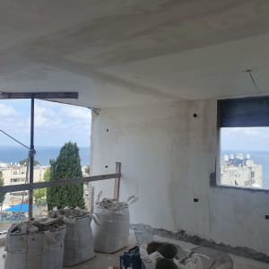 שקיות חומרי בנייה וחלון עם נוף לים