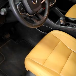 מושב עור צהוב בהיר והגה רכב עם לוגו