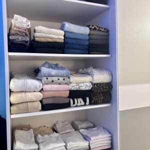 בגדים מקופלים ומסודרים בארון לבן