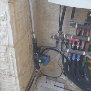 מערכת השקיה עם צינורות וברזים על קיר אבן