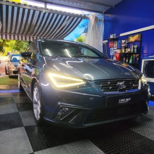 מכונית כחולה עם פנסים דולקים במוסך