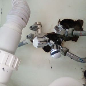 צינורות מים וברזים מתכתיים מתחת לכיור