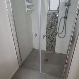 מקלחון עם מדף מוצרים, ראש מקלחת ודלת זכוכית