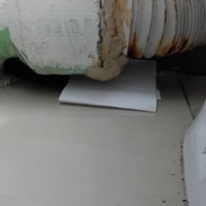 צינור עם חלודה ונייר מתחתיו