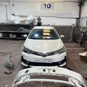 רכב לבן במוסך עם פגוש קדמי מנותק
