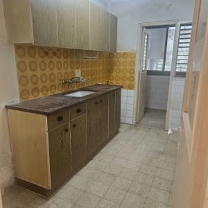 מטבח ישן עם ארונות וכיור