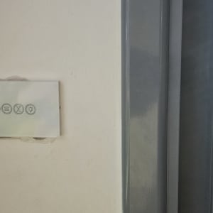 מתג חשמלי על קיר ליד חלון עם תריסים