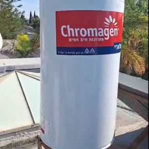 דוד שמש כרומגן על גג עם צמחייה ברקע