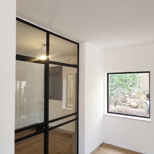 חדר עם חלונות זכוכית ודלתות שחורות
