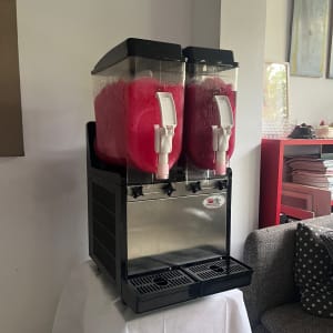 מכונת ברד כפולה עם נוזל ורוד על שולחן לבן