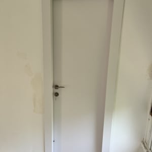 דלת לבנה עם ידית מתכת ומפתח