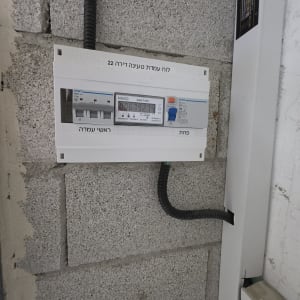 לוח חשמל מותקן על קיר בטון אפור