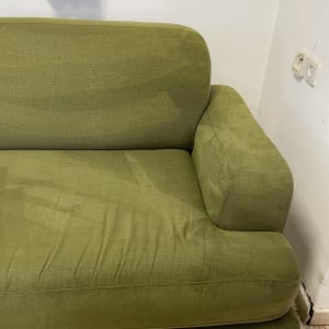 ספה ירוקה עם כתמי לכלוך נראים לעין