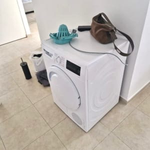 מכונת כביסה עם חפצים על הרצפה