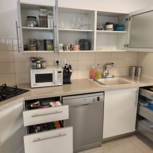 מטבח מסודר עם ארונות פתוחים וכלים מסודרים