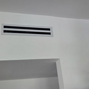 פתח אוורור על קיר לבן בחדר