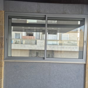 חלון אלומיניום עם מסגרת אפורה