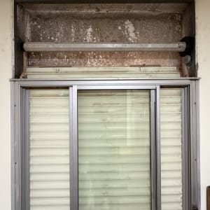 חלון עם תריסים ישנים ומסגרת מתכת