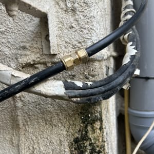 חיבור צינור עם מחבר מתכת על קיר חיצוני