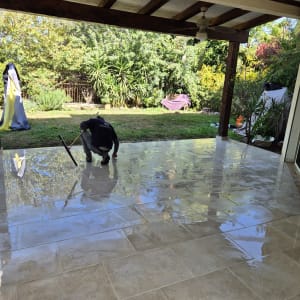 אדם מנקה רצפת מרפסת עם מגב