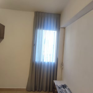 וילון אפור תלוי על חלון בחדר