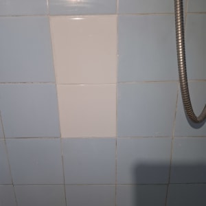 אריחי קרמיקה עם צינור מתכת במקלחת