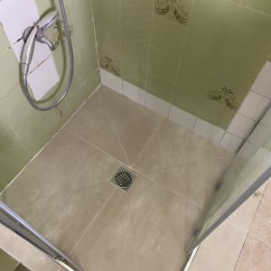 מקלחת עם אריחים ירוקים וראש מקלחת