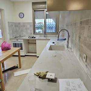 מטבח חדש עם ארונות לבנים ומשטח עבודה