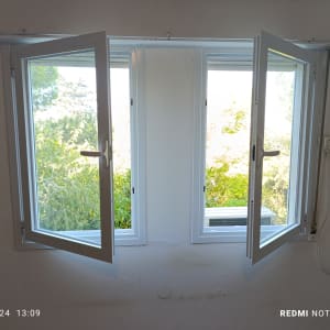 חלון אלומיניום פתוח עם מסגרת לבנה