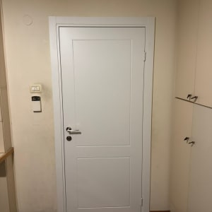 דלת לבנה עם ידית כסופה בחדר פנימי
