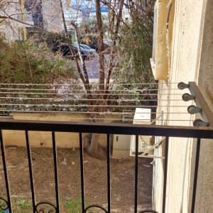 מרפסת עם חבלי כביסה ועצים ברקע