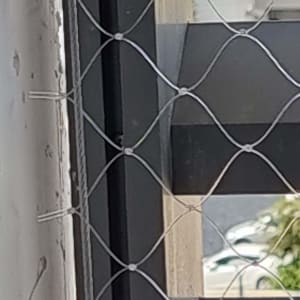 רשת מתכת מותקנת על חלון למניעת כניסת יונים