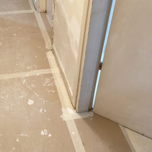 קירות מוכנים לצביעה עם נייר מגן על הרצפה