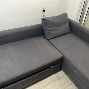 ספה אפורה נקייה עם כרית על רצפת עץ