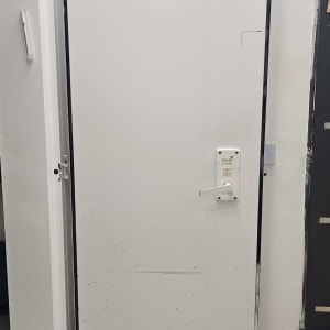 דלת לבנה עם ידית ומסגרת שחורה