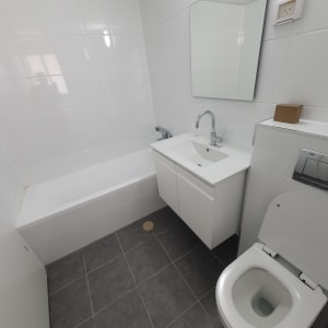 חדר אמבטיה נקי עם כיור, אסלה ואמבטיה