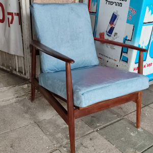 כיסא עץ עם ריפוד כחול על מדרכה