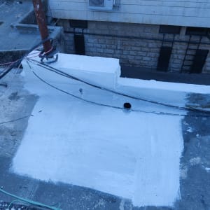 אזור אטום בלבן על גג עם צינור וכבלים