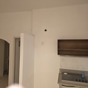 קיר צבוע עם חור קטן ליד מטבח